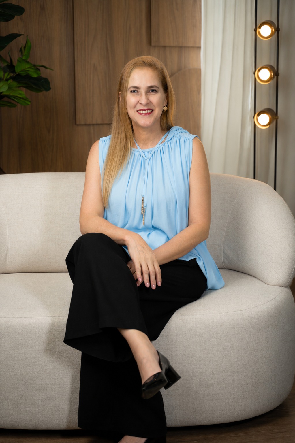 Fernanda Pessoa sentada num sofá, sorrindo